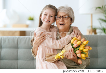 Grandma and girl smiling and hugging 111309842