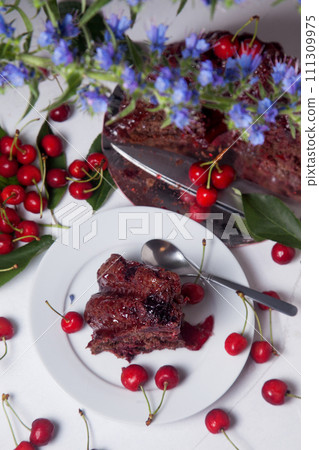 Chocolate cake with sweet cherry, cup of tea and bouquet of blue flowers on white background.. 111309975