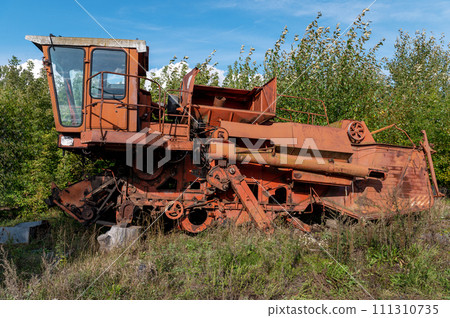 Old rusty agricultural machinery. Abandoned harvester, tractor Old rusty agricultural machinery. Abandoned harvester, tractor 111310735