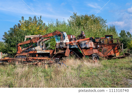 Old rusty agricultural machinery. Abandoned harvester, tractor 111310740