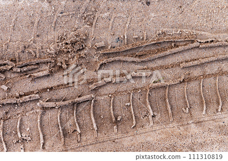 Car tread on the sand. Tread marks from car wheels on a dirt road made of sand. View from above. 111310819