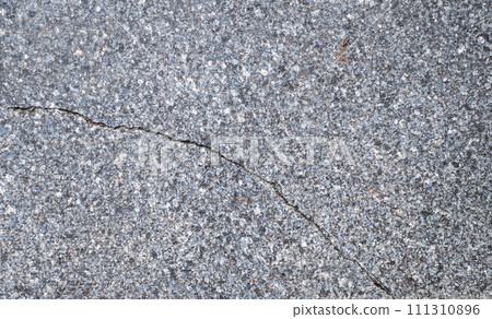 Old grey granite tiles are laid on the streets of the city. Cracked granite tiles 111310896
