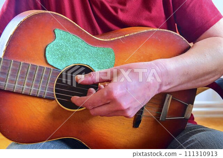 The hand of man playing guitar. Closeup. Musical concept 111310913