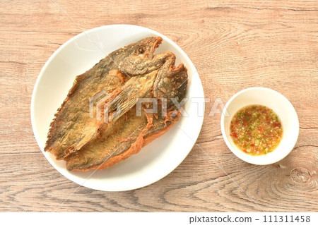 deep fried black-banded trevally fish on plate dipping spicy chili sauce   111311458