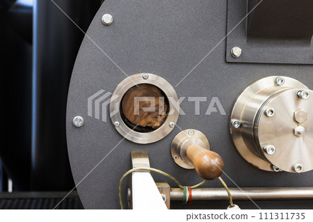 Industrial coffee roaster close-up photo, roasting coffee seeds Industrial coffee roaster close-up photo, roasting coffee seeds 111311735