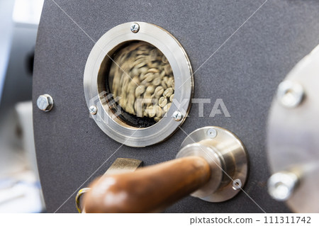 Industrial coffee roaster close-up photo, green seeds are inside Industrial coffee roaster close-up photo, green seeds are inside 111311742