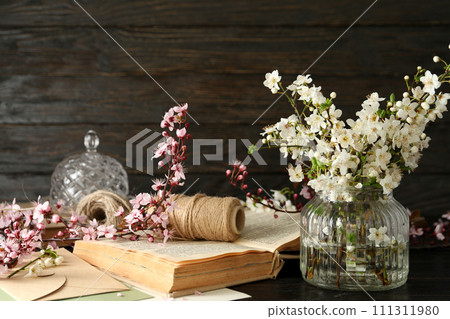 Spring twigs with flowers in a jar, on a dark wooden background. Spring twigs with flowers in a jar, on a dark wooden background. 111311980
