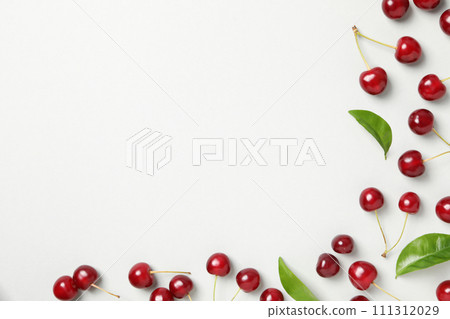 Ripe juicy cherry fruits with leaves on a white background Ripe juicy cherry fruits with leaves on a white background 111312029