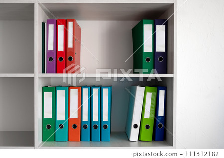 Office shelves with colorful folders. Folders on the shelves in the office closet. Office shelves with colorful folders. Folders on the shelves in the office closet. 111312182