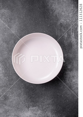 Empty round ceramic plate on a light texture background Empty round ceramic plate on a light texture background 111312628