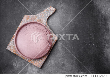 Empty round ceramic plate on a light texture background Empty round ceramic plate on a light texture background 111312635