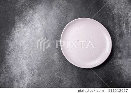 Empty round ceramic plate on a light texture background Empty round ceramic plate on a light texture background 111312637