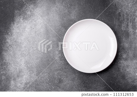 Empty round ceramic plate on a light texture background Empty round ceramic plate on a light texture background 111312653
