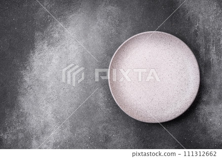 Empty round ceramic plate on a light texture background 111312662