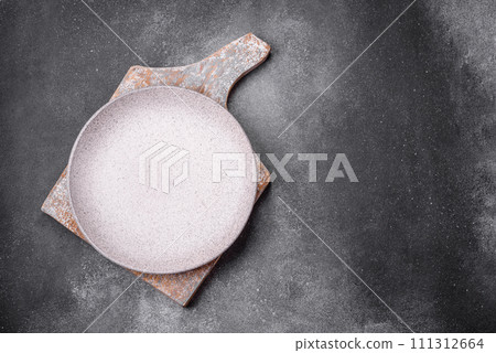 Empty round ceramic plate on a light texture background 111312664