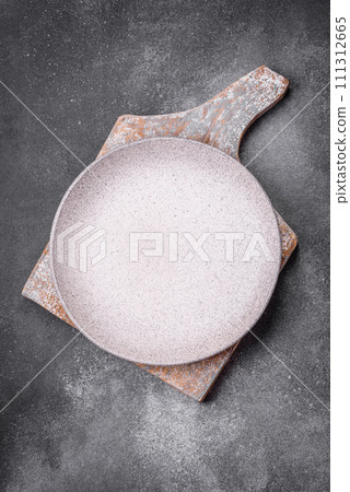 Empty round ceramic plate on a light texture background Empty round ceramic plate on a light texture background 111312665