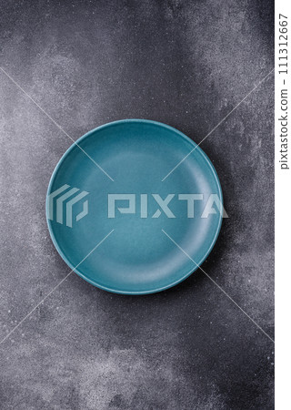 Empty round ceramic plate on a light texture background Empty round ceramic plate on a light texture background 111312667