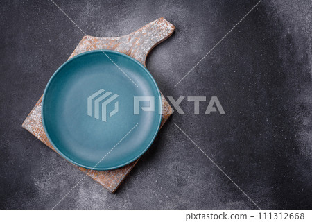 Empty round ceramic plate on a light texture background Empty round ceramic plate on a light texture background 111312668