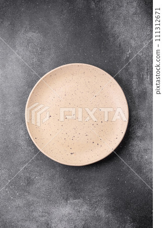 Empty round ceramic plate on a light texture background Empty round ceramic plate on a light texture background 111312671