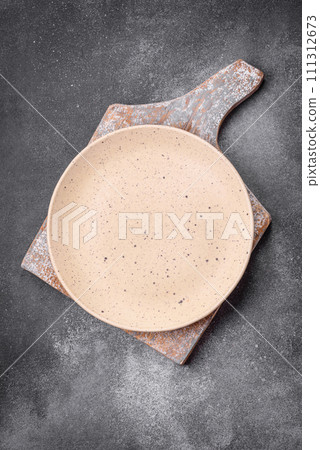 Empty round ceramic plate on a light texture background Empty round ceramic plate on a light texture background 111312673