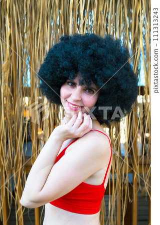 Beautiful brunette in a red top near a straw house 111313243