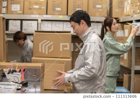 Men and women in work clothes doing packing work 111313606