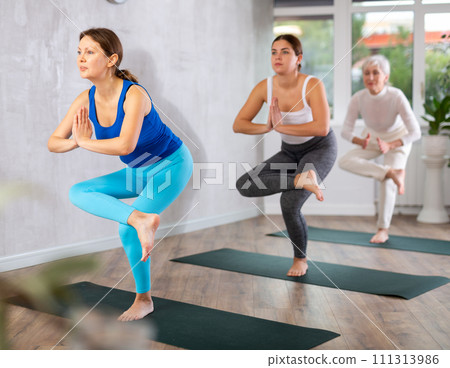 Adult woman doing yoga in fitness studio Adult woman doing yoga in fitness studio 111313986