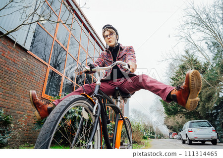 Male student in helmet on cruiser Bicycle spreading wide legs and screaming when riding bike on urban sidewalk. No traffic jams, Eco friendly transportation for carbon footprint. Sustainable lifestyle Male student in helmet on cruiser Bicycle spreading wide legs and screaming when riding bike on urban sidewalk. No traffic jams, Eco friendly transportation for carbon footprint. Sustainable lifestyle 111314465
