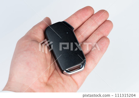 Modern car key in hand palm Modern car key in hand palm 111315204