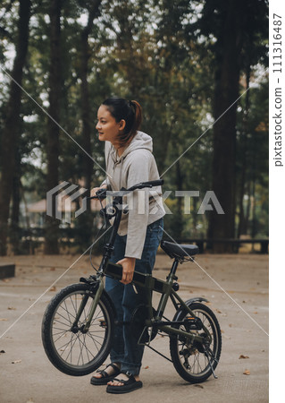 Happy Asian young woman walk and ride bicycle in park, street city her smiling using bike of transportation, ECO friendly, People lifestyle concept. 111316487
