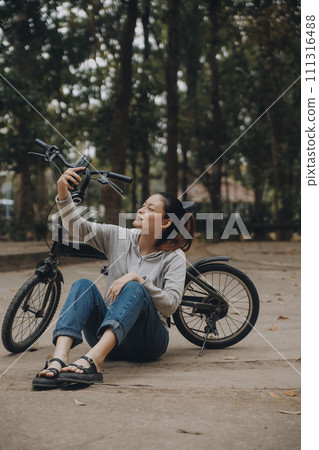 Happy Asian young woman walk and ride bicycle in park, street city her smiling using bike of transportation, ECO friendly, People lifestyle concept. Happy Asian young woman walk and ride bicycle in park, street city her smiling using bike of transportation, ECO friendly, People lifestyle concept. 111316488