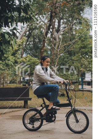 Happy Asian young woman walk and ride bicycle in park, street city her smiling using bike of transportation, ECO friendly, People lifestyle concept. Happy Asian young woman walk and ride bicycle in park, street city her smiling using bike of transportation, ECO friendly, People lifestyle concept. 111316560