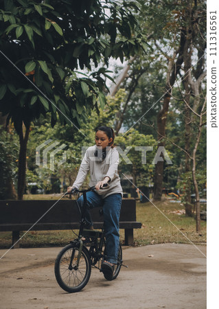 Happy Asian young woman walk and ride bicycle in park, street city her smiling using bike of transportation, ECO friendly, People lifestyle concept. Happy Asian young woman walk and ride bicycle in park, street city her smiling using bike of transportation, ECO friendly, People lifestyle concept. 111316561