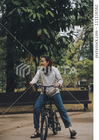 Happy Asian young woman walk and ride bicycle in park, street city her smiling using bike of transportation, ECO friendly, People lifestyle concept. 111316562