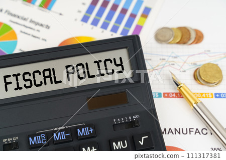 On the table are financial reports, coins and a calculator with the inscription - Fiscal policy 111317381