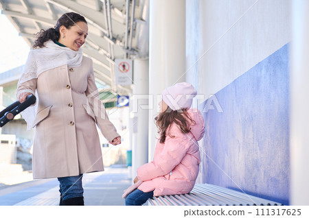 Mother and daughter waiting high-speed train in the train station 111317625