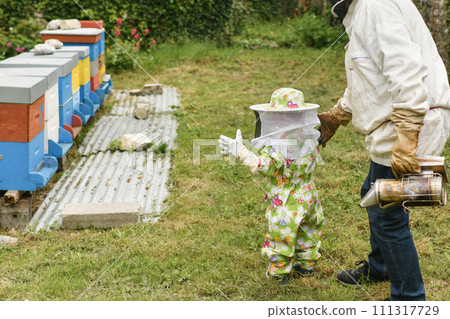 The beekeeper shows the beehive to the children 111317729
