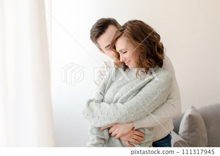 Romantic couple hugging and kissing at home during weekend 111317945