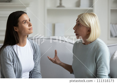 Strict anxious mature mother lecturing annoyed grown daughter Strict anxious mature mother lecturing annoyed grown daughter 111318173