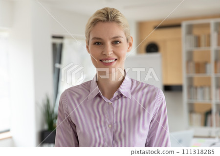 Headshot portrait of smiling female employee in office 111318285