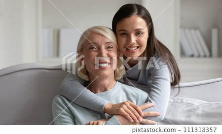 Head shot portrait mature grandmother and granddaughter hugging Head shot portrait mature grandmother and granddaughter hugging 111318357