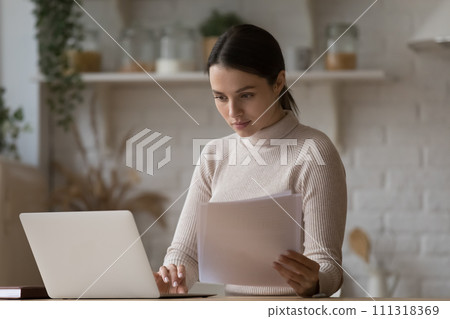 Woman do paperwork, paying household bills via e-bank using laptop 111318369