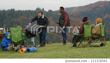 Caucasian man cooks in barbecue grill on the hill for friends and kids Caucasian man cooks in barbecue grill on the hill for friends and kids 111318565