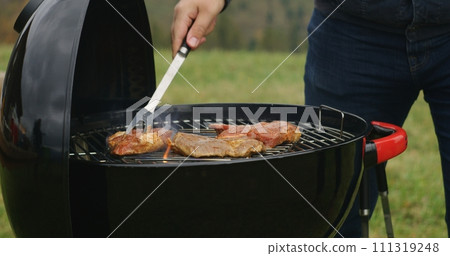 Man cook tasty dinner on BBQ grill outdoor 111319248