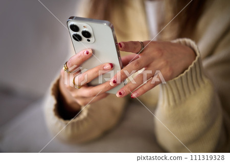 Parts cut of a young woman operating a smartphone Parts cut of a young woman operating a smartphone 111319328