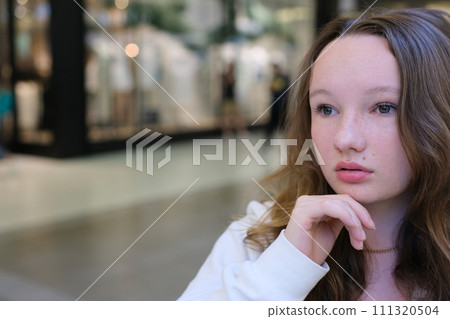 Portrait of a young pretty caucasian teenage girl with long hair in a blue shirt in a mall. High quality photo Portrait of a young pretty caucasian teenage girl with long hair in a blue shirt in a mall. High quality photo 111320504