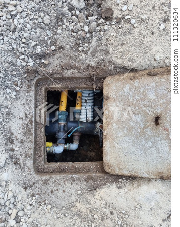 A Gas Meter Is Sitting In A Hole In The Ground 111320634