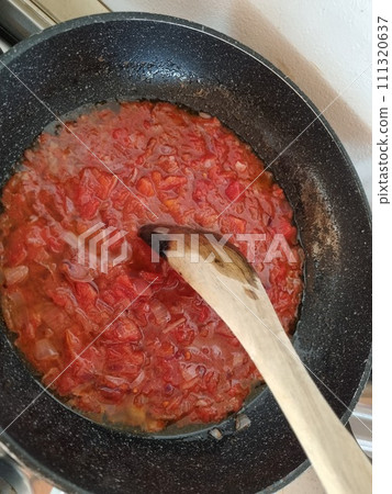A Frying Pan Filled With Tomato Sauce And A Wooden Spoon. Tomato Sausage 111320637