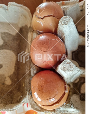 Three Broken Eggs In A Cardboard Box On A Table Three Broken Eggs In A Cardboard Box On A Table 111320646