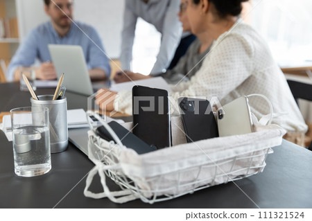Smartphones in basket during meeting in office 111321524